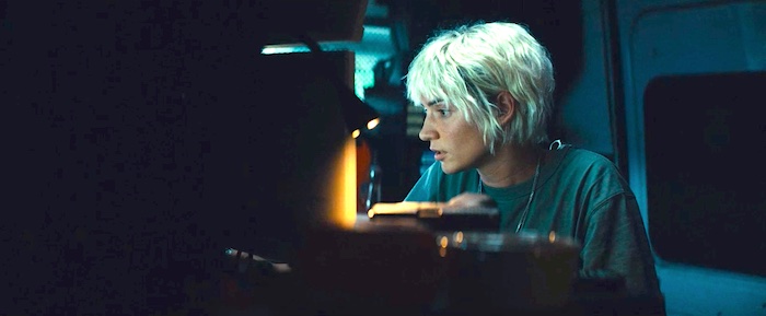 La jeune femme policier chargée des écoutes téléphoniques dans sa camionnette banalisée est un autre personnage féminin fort du film AKA